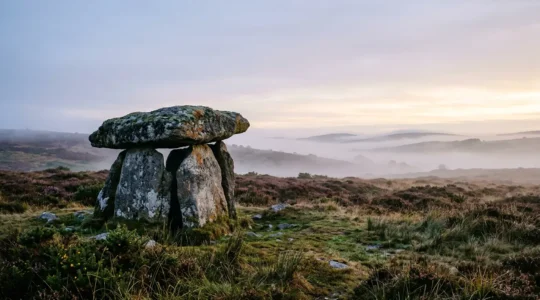 Dolmen ancien dans la brume bretonne au lever du soleil, évoquant les légendes celtiques