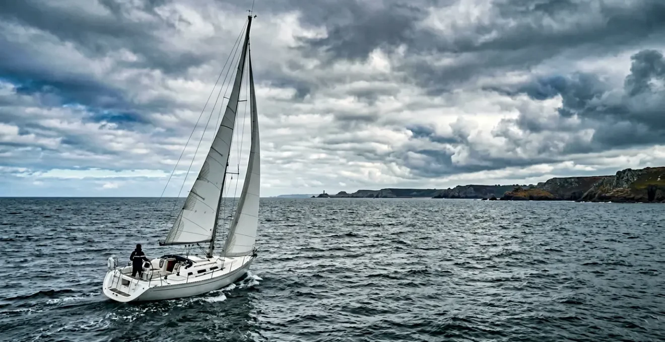 Vue panoramique d'un voilier naviguant dans les eaux bretonnes sous un ciel dynamique