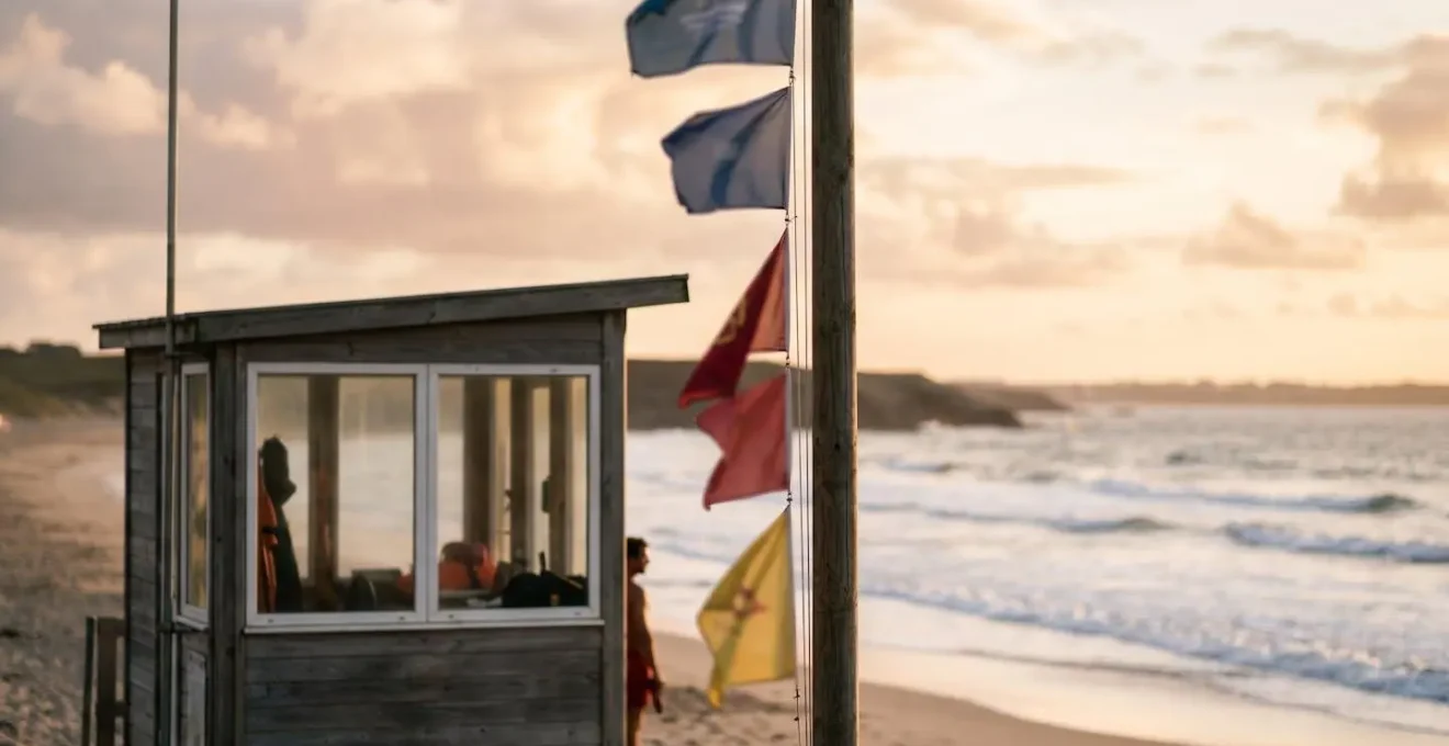 Poste de surveillance de plage bretonne avec mât de drapeaux de sécurité face à l'océan Atlantique